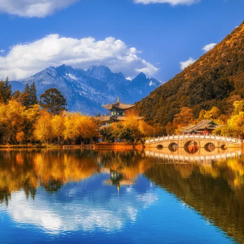 Reflejo del pabellón tradicional y la Montaña de Nieve del Dragón de Jade en un lago de Lijiang, China